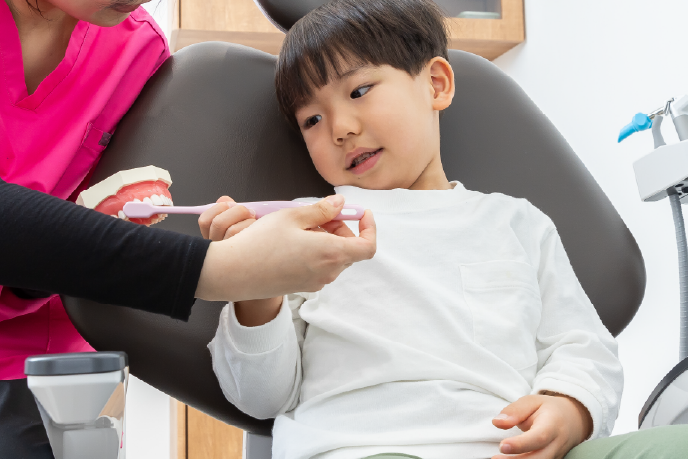 お子様の処置をする院長と、サポートするスタッフ